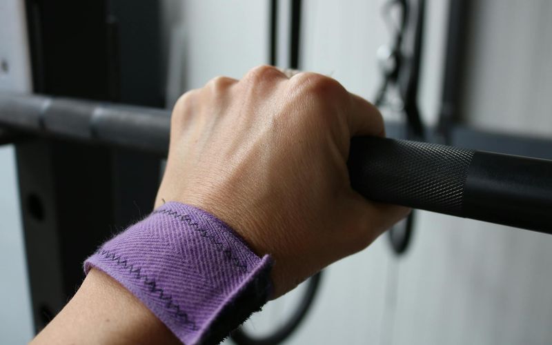 Close-up of hands gripping a pull-up bar with determination.
